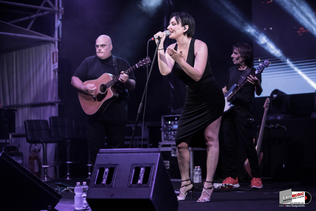 Arisa canta sul palco con i musicisti durante il Baciami Stupido Tour